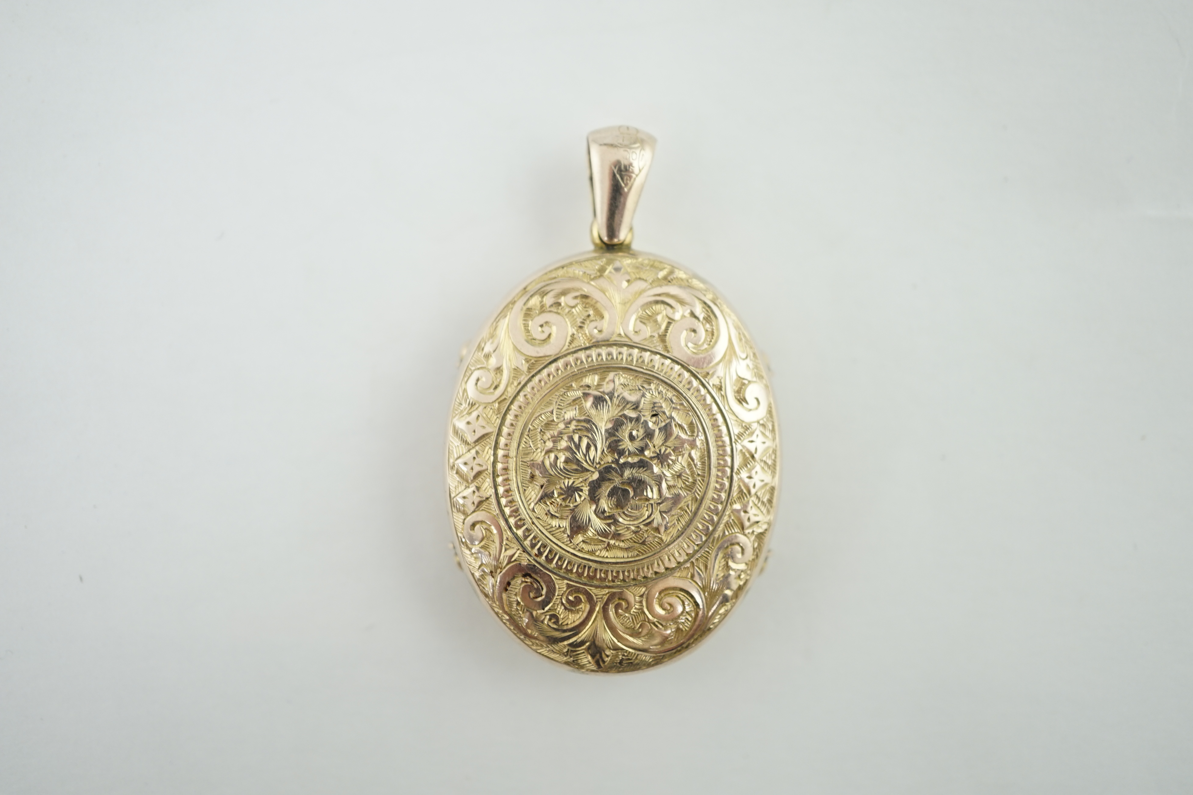 A Victorian floral and scroll engraved locket